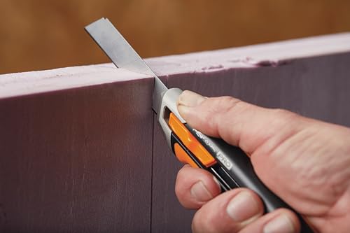 Fiskars Cuttermesser in der Hand, schwarz-orange, mit scharfer Klinge, ideal für präzise Schneidarbeiten, ergonomisches Design.
